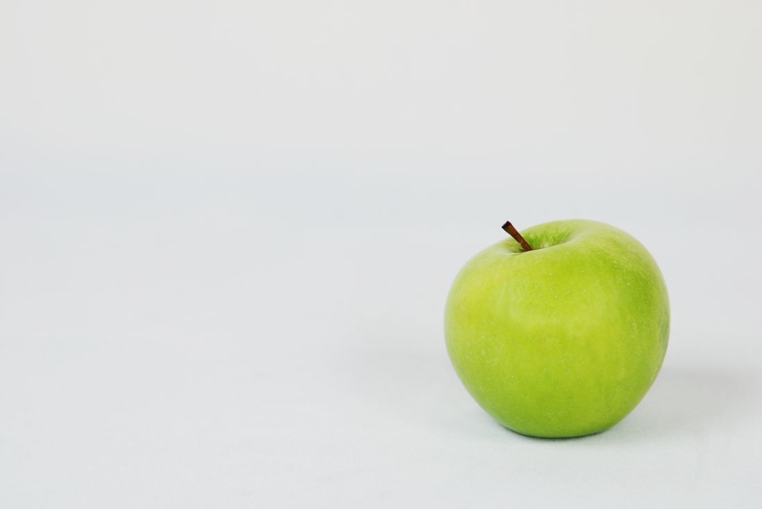 A whole green apple with its skin intact